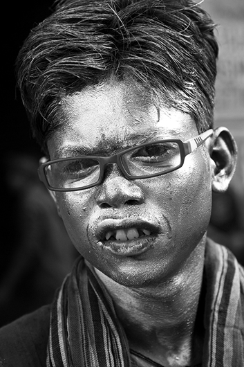 boy painted face holi festival varanasi uttar pradesh India Asia NO MR