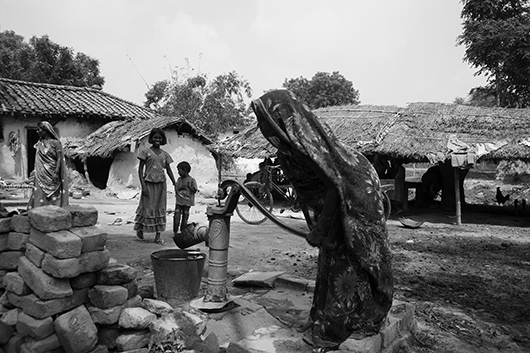 woman pumping hand pump varanasi uttar pradesh India Asia
